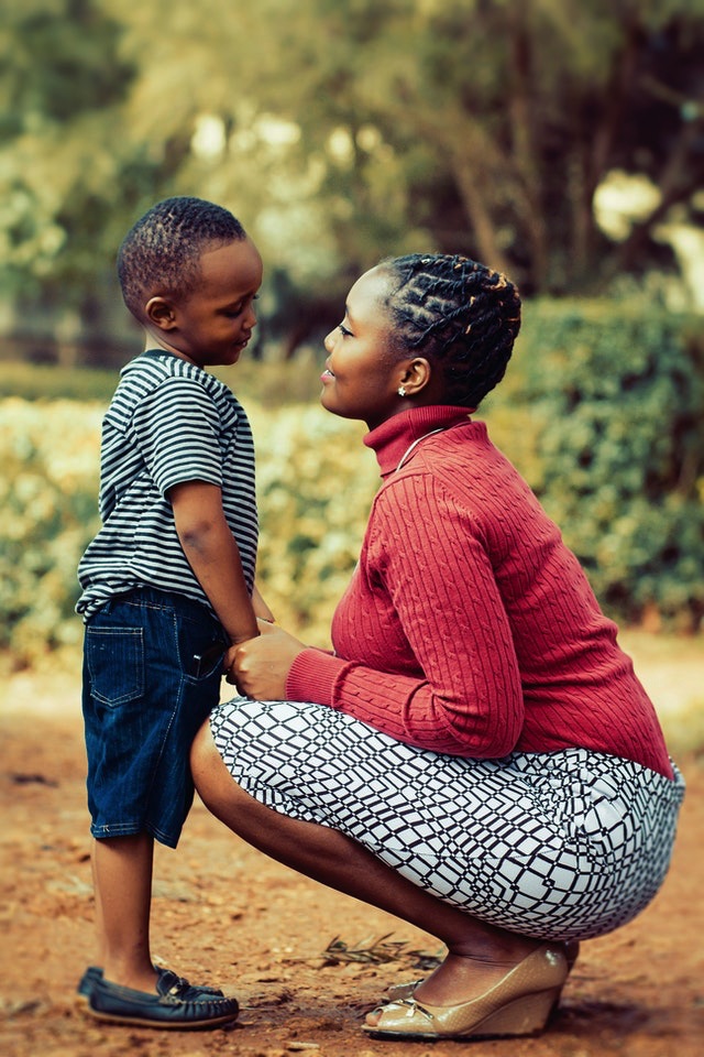 A mother squatting to meet her son's height